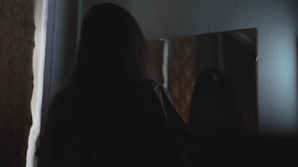 Dark cinematic Halloween shot featuring a possessed woman staring into an antique mirror in a haunted setting. Perfect for horror intros, thriller trailers, or supernatural themed - Powered by Adobe