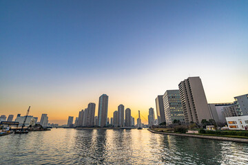 Fototapeta premium 夕焼けの中の水辺の高層マンション