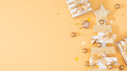 Festive background with gift boxes, glittery golden star tree, and ornaments on a warm peach...
