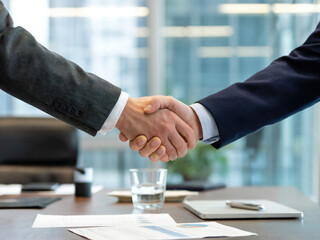 Professional business handshake in modern office building, partnership agreement and corporate success concept, businessmen shaking hands for teamwork and cooperation