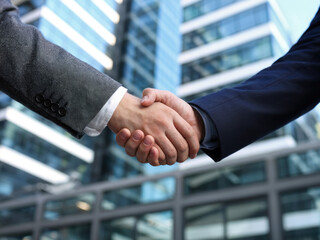 Professional business handshake in modern office building, partnership agreement and corporate success concept, businessmen shaking hands for teamwork and cooperation