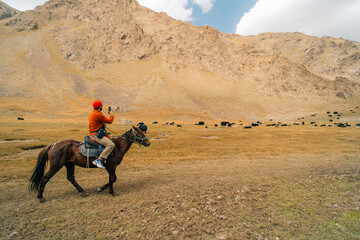 Tourists on horseback in Kurumduk valley Naryn province, Kyrgyzstan