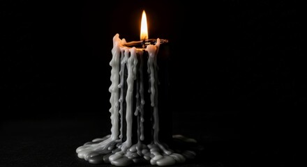 Single burning candle with melted wax dripping down. Concept of hope, memory, or mourning in darkness. Perfect for somber occasions