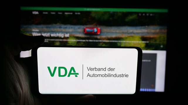 Stuttgart, Germany - 10-06-2025: Person holding cellphone with logo of German Verband der Automobilindustrie (VDA) on screen in front of webpage. Focus on phone display.