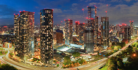Blue-hour panorama of Manchester’s illuminated skyline featuring Deansgate Towers and Mancunian Way.