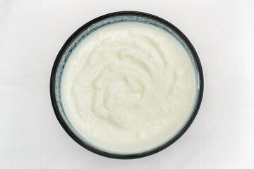 Homemade dahi, doi or sour cream or curd or yogurt in bowl on white background. Curdled milk. Probiotic food or Probiotic dairy product concept. It is popular Indian dessert.