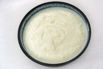 Homemade dahi, doi or sour cream or curd or yogurt in bowl on white background. Curdled milk. Probiotic food or Probiotic dairy product concept. It is popular Indian dessert.