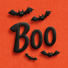 spooky halloween greeting boo word and flying bats on a vibrant orange felt texture background
