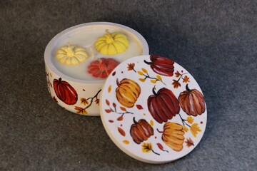 An autumn decorative container with a pumpkin-shaped candle is a stylish prop for advertising home...