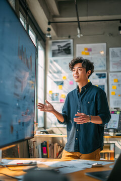 Young man presents data analysis in a modern office during the day