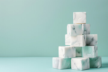 Marble blocks are carefully stacked into a modern geometric shape, creating a visually appealing display against a soft blue backdrop. The design shows texture and symmetry