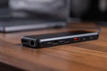 Black USB-C hub offering diverse expansion ports like HDMI and Ethernet, optimizing laptop connectivity and modern workflow for digital professionals