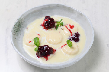 Syrniki in milk-vanilla sauce with cherry jam and mint