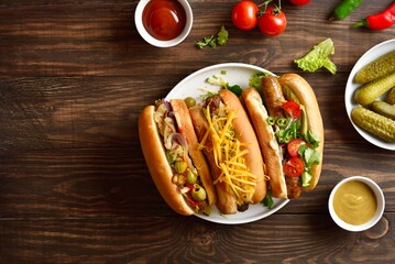 Hot dogs with different toppings on wooden background