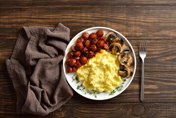 Mashed potatoes with roasted sweet and spicy sausage bites and mushrooms