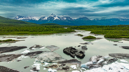 Alaskan lagoon with icebergs and mountain panorama. Aerial view of Alaskan lagoon filled with...