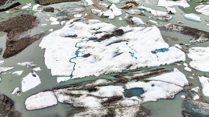 Close-up aerial view of icebergs floating in Alaska lagoon. Floating icebergs and ice formations in...