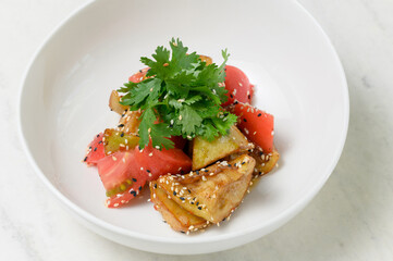 Roasted eggplant and fresh tomato salad with sesame and cilantro