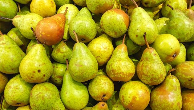 A close-up view of a large pile of pears with varied hues of green and orange skin, arranged in a dense arrangement - Powered by Adobe
