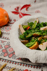 Fresh salad with chicken, greens and vegetables in a white plate