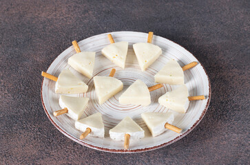 Brie cheese Christmas trees with straws laid out on plate. Preparation process, step by step