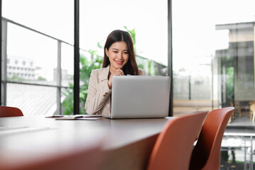 Businesswoman sitting working in office with laptop on desk