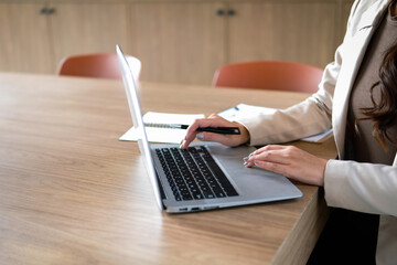 Businesswoman sitting working with laptop on desk in office