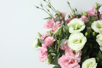 Beautiful bouquet of eustoma flowers on a white background, space for text