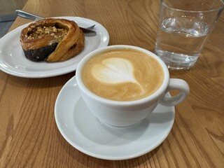 Fragrant cappuccino in white cup on the table in a cafe, close up