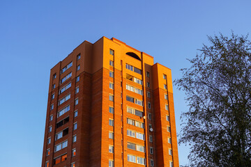Residential building standing tall against a clear blue sky in an urban setting