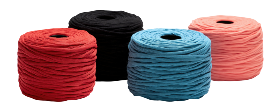 Four spools of yarn in vibrant colors, neatly wound and arranged against a black background