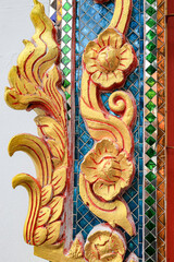 Beautiful detail of traditional Thai art decorated made from ceramic tile and paint, on the wall of building of public Buddhist temple, textures background.
