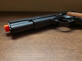 Obraz premium Toy Gun with Orange Tip. Though just an airsoft replica, the photo showcases the weapon's beauty, evoking power and danger