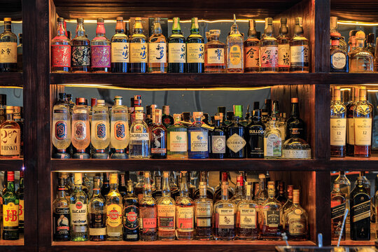 An assortment of high-class liquor in a luxury hotel bar.
