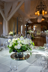 Elegant wedding banquet hall features a stunning floral centerpiece, soft lighting, and a romantic atmosphere, creating a perfect celebration setting