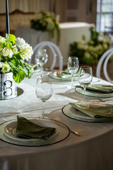 Elegant wedding banquet hall features a beautifully set table with floral centerpiece, glassware, and fine dining elements creating a romantic ambiance