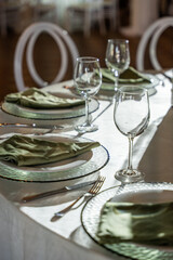Elegant wedding banquet hall table setting features glassware, folded linens, and decorative plates, creating a sophisticated dining atmosphere
