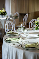 Elegant wedding banquet hall features a beautifully set table with floral centerpiece, glassware, and soft lighting creating a romantic atmosphere