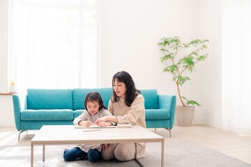 幼稚園児の女の子と一緒に勉強をするお母さん