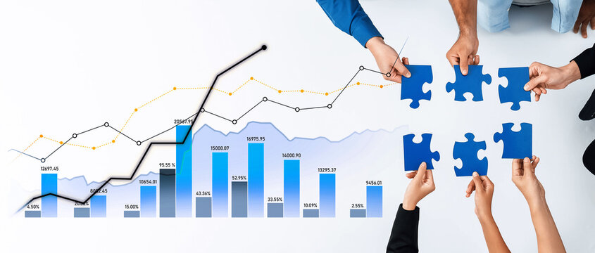 Hands collaborate to fit puzzle pieces together while analyzing growth charts, symbolizing teamwork in business strategy and financial planning for success. Scalp