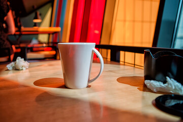 White cup on a café table, dramatic lighting, coffee break