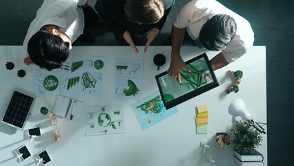 Top view of manager hold tablet display clean energy investment at meeting. Aerial view of skilled...