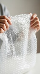 Hands Holding Bubble Wrap for Protection and Packaging.