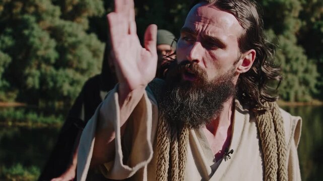 A cinematic video scene of biblical figures by a river, captured from a low angle, emphasizing the serene landscape and historical attire.