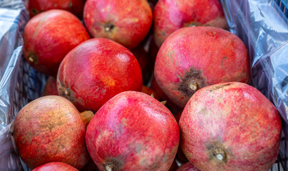 Ripe red fresh pomegranate fruit (Nar). They are being packed into crates to be sent to the market....