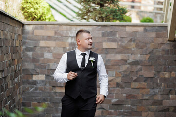 Man dressed in formal attire walking confidently in a garden setting during a celebration