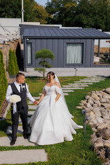 Fototapeta premium Couple enjoys outdoor wedding celebration near modern house in bright daylight