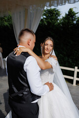 Couple shares a romantic moment at a wedding ceremony under a beautiful canopy