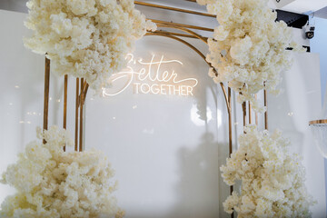 Beautiful floral arch with glowing sign at a celebration event in a modern venue