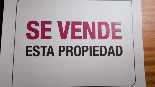 Letrero se vende esta propiedad impreso en papel sobre mesa 11